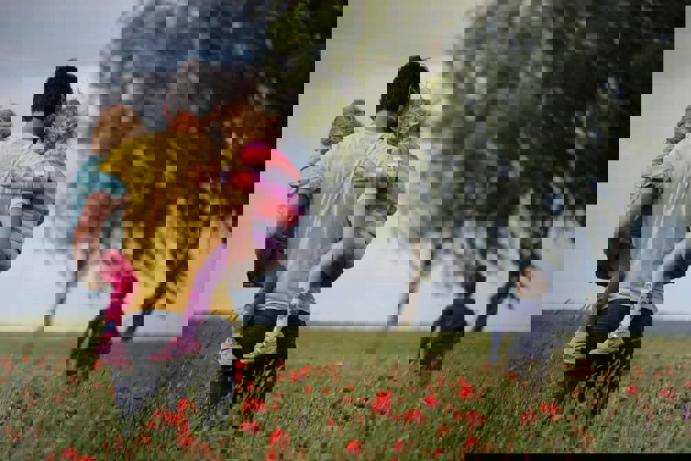 Man holding children in poppy field
