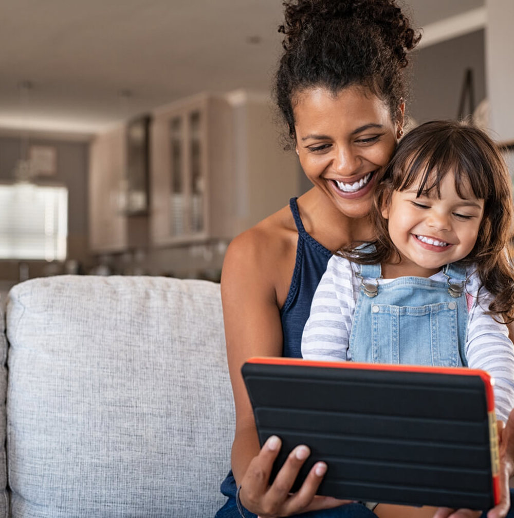African Smiling Mother And Happy Daughter Using Digital Tablet